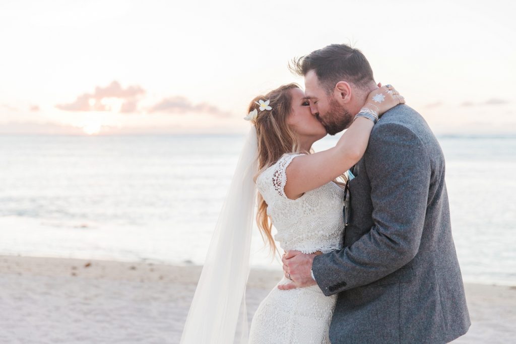 Bride and groom kiss at sunset after their Mauritius wedding