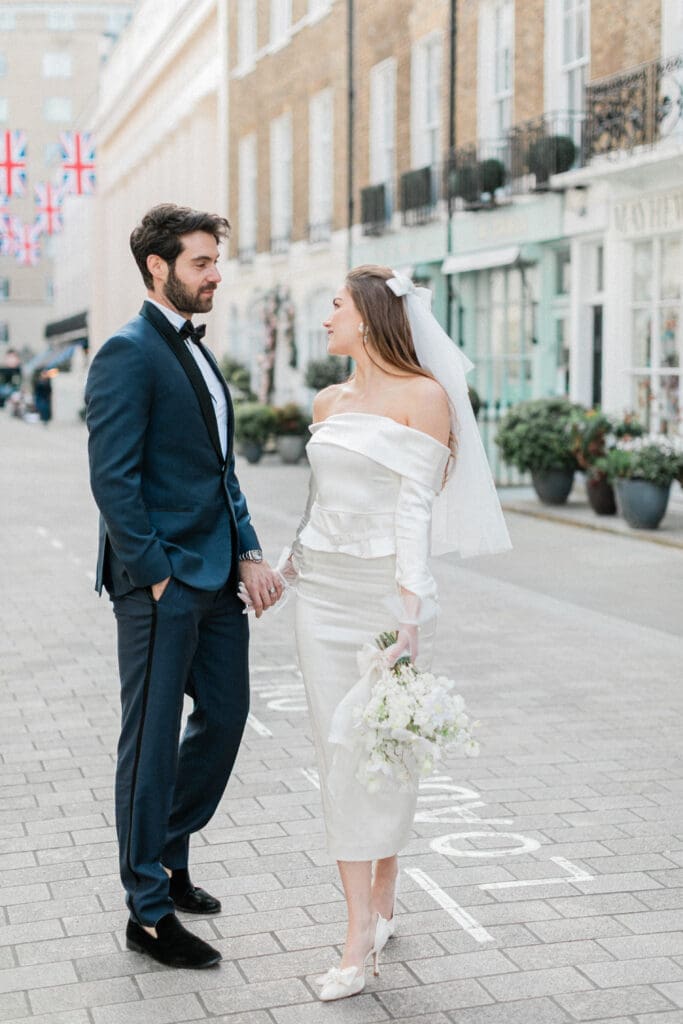Bride and Groom walking along the streets of London whilst looking romantically at each other.