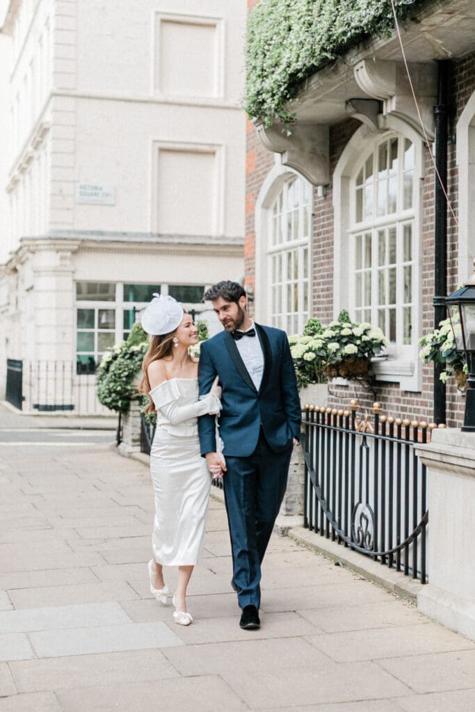 Bride and Groom walking along the street outside The Goring in Belgravia, after their wedding ceremony.