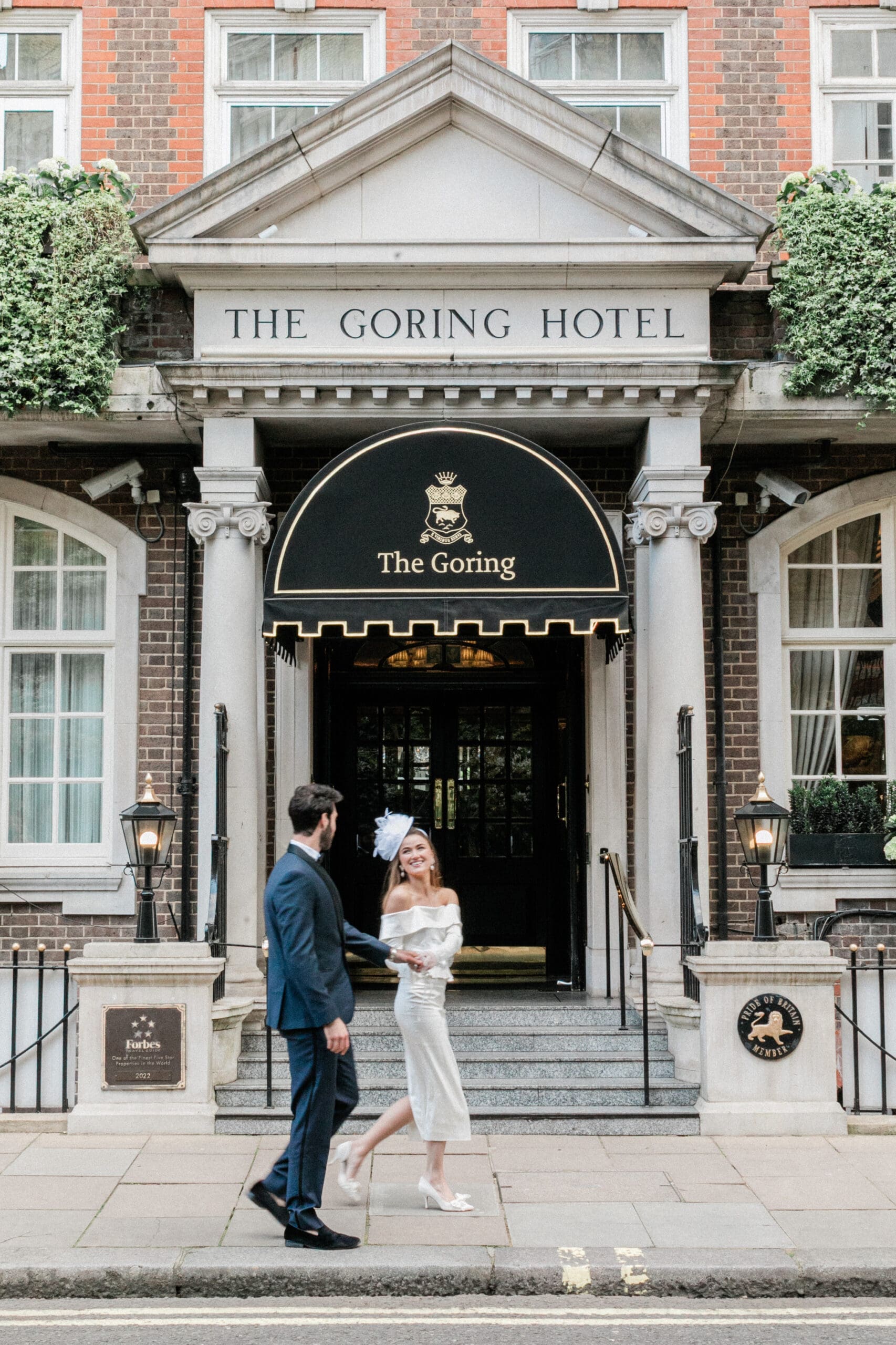 Bride & Groom walking outside the front door of The Goring in Belgravia, London after their legal ceremony