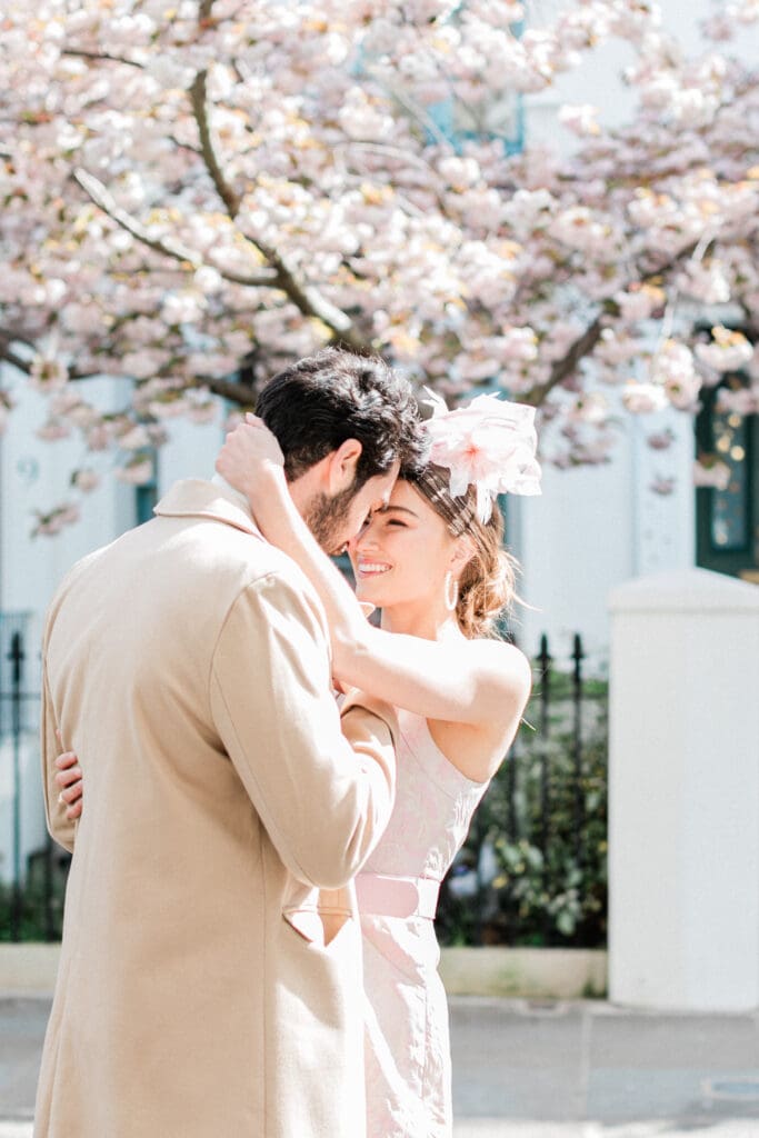 A couple posing face to face romantically outside a white townhouse for their engagement shoot in Notting Hill 