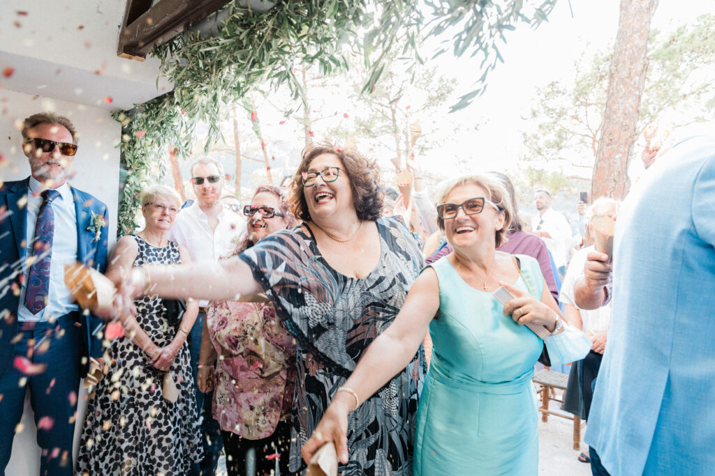 Family and friends throwing confetti in celebration of a wedding.