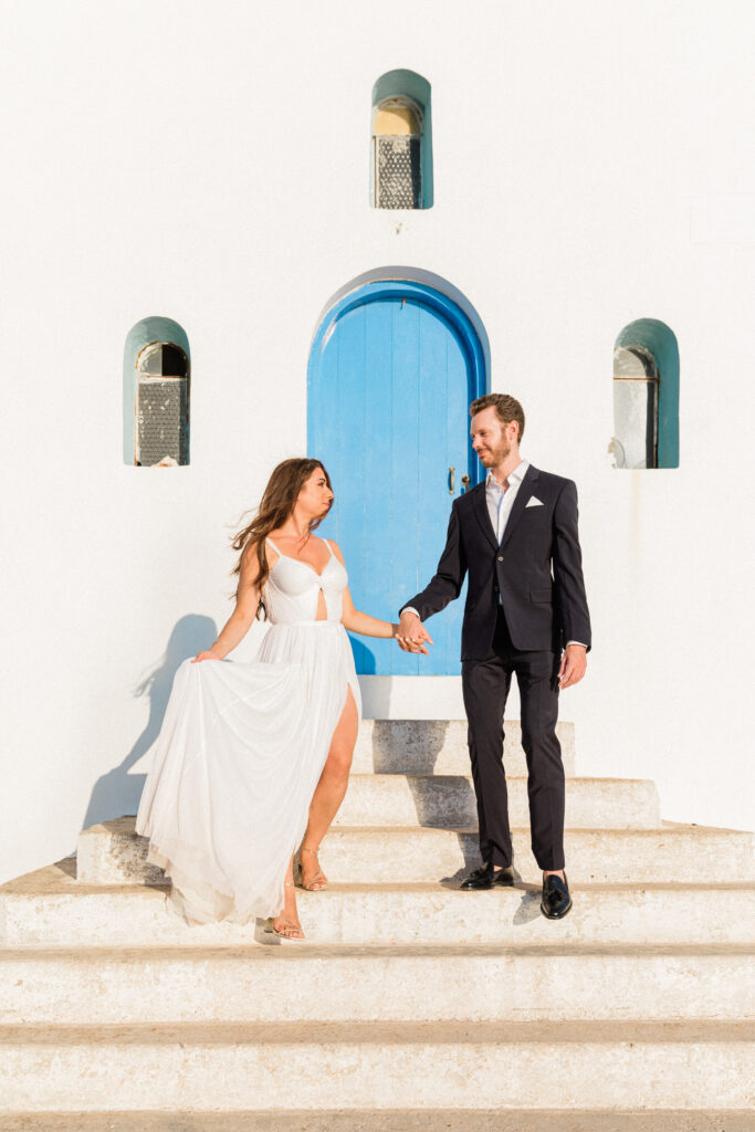 The bride and groom stood outside a traditional Greek building at their Ithaca wedding.