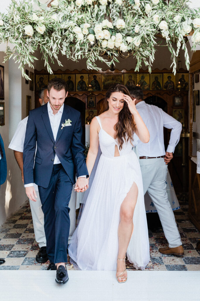 The bride and groom walking out of the church after getting married at a church in Ithaka, Greece.
