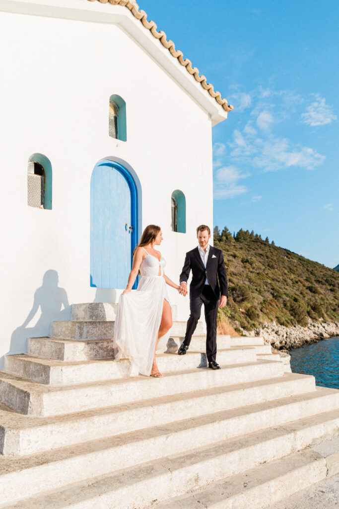 The bride and groom stood outside a traditional Greek building at their Ithaca wedding.