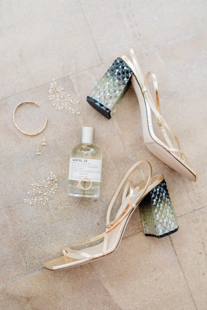 Flatlay of the bride's wedding shoes, perfume and jewellery ahead of her greek wedding in Ithaca.